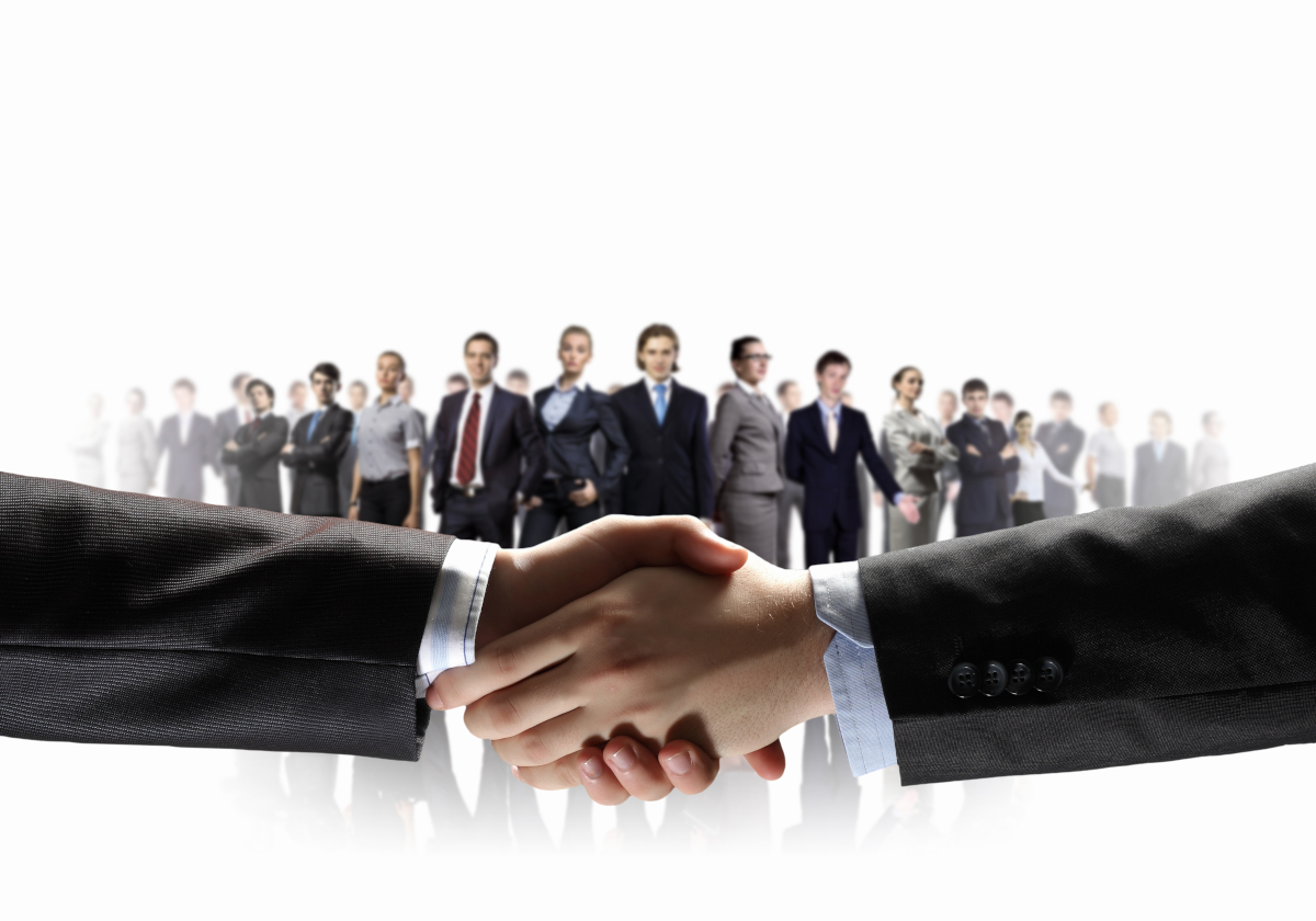 Two hands shaking in front of a line of people in a white scape