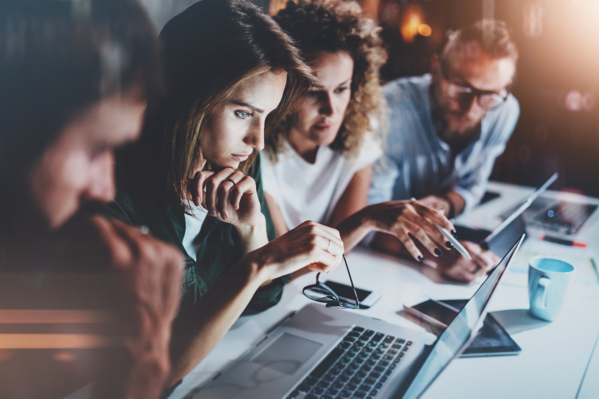 A group of people assessing something on a laptop