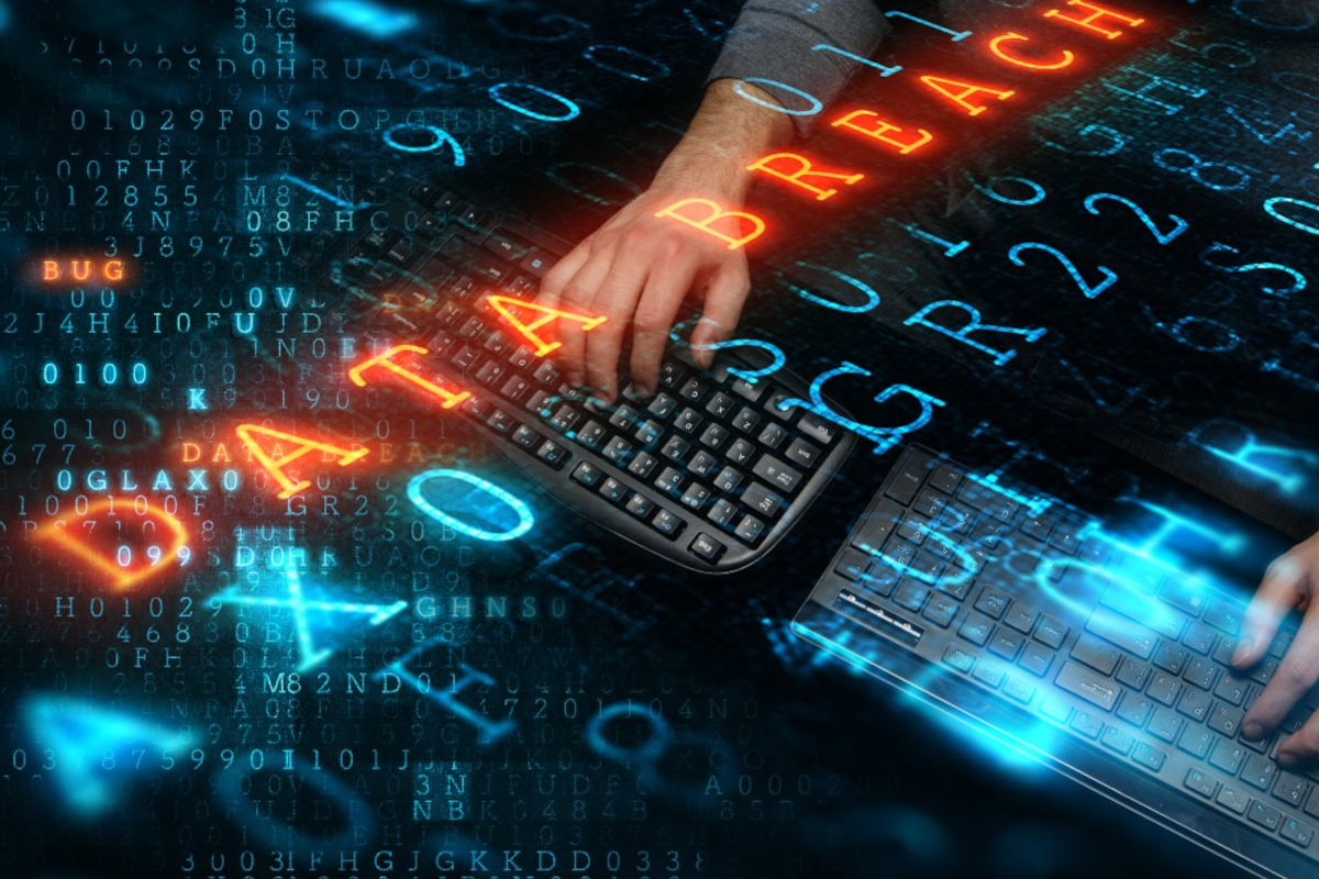 Hands typing on keyboards beneath glowing DATA BREACH text over binary code