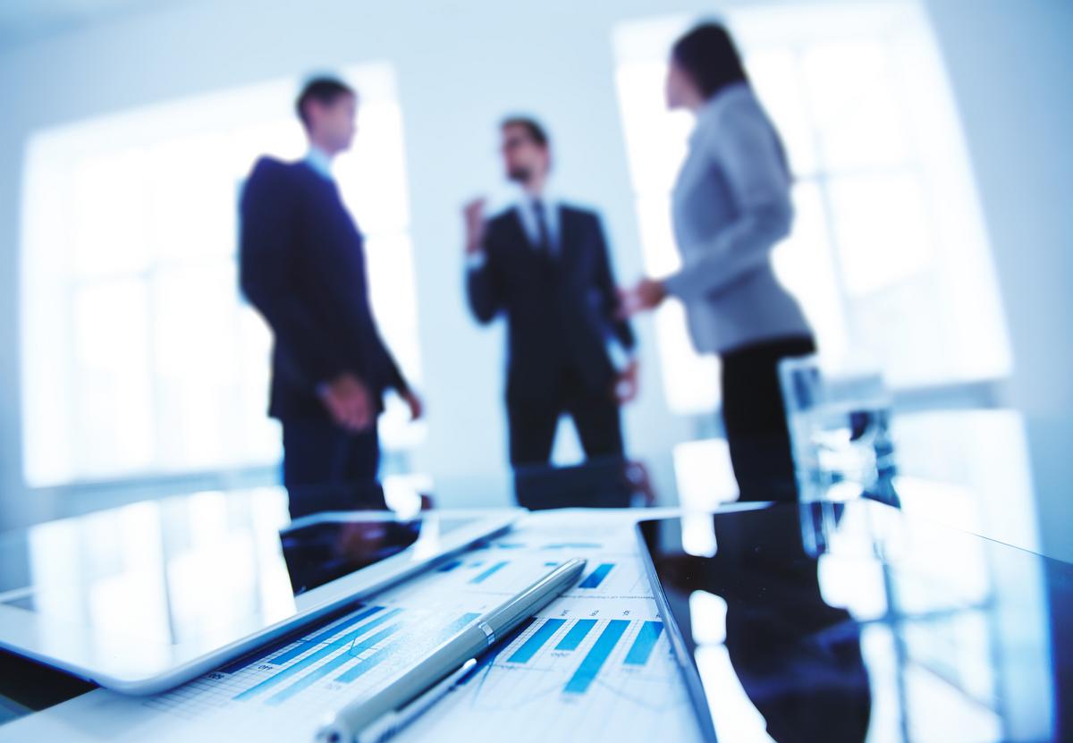 Business Desk and Business People Talking in the Background