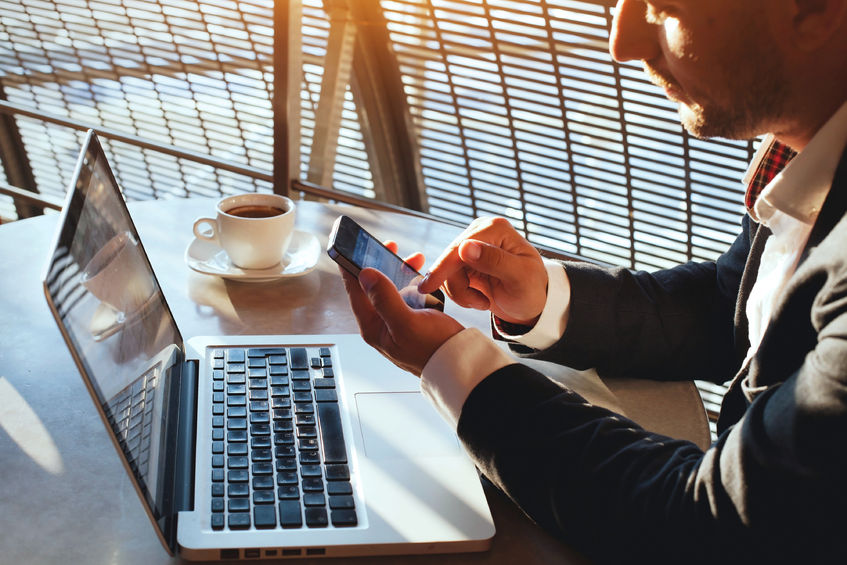 A businessman working remotely on his laptop and phone